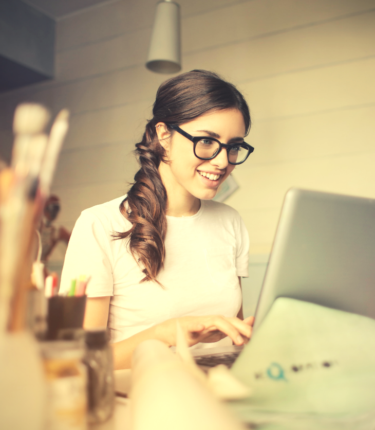 woman with glasses job hunting on laptop